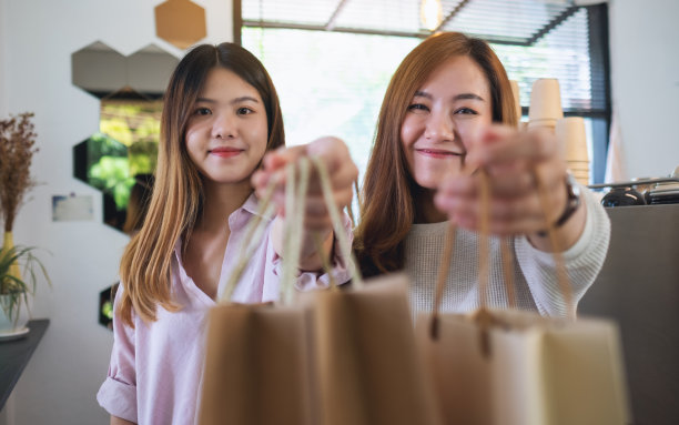 两个年轻的妇女拿着购物袋展示图片下载