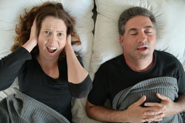 女人因男人在床上睡觉而打鼾图片下载