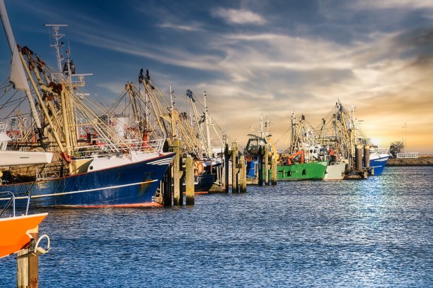 荷兰格罗宁根劳沃苏格港口渔船，日落的天空，蓝色的海水图片下载