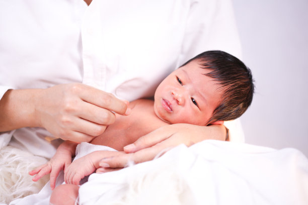 母亲把婴儿抱在膝上。宝宝和妈妈睡在一起。图片下载