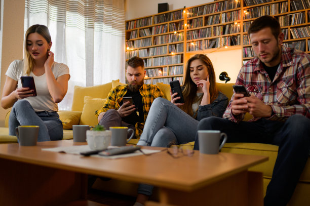 朋友们在无聊的家庭聚会上看手机图片下载