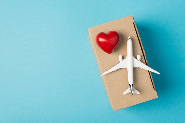 头顶上人道主义援助捐赠飞机和盒子的照片，蓝色背景上有空白区域，孤立的红心图片下载