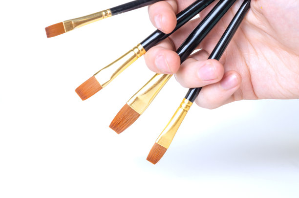 画家的手握着画笔在白色的背景上作画。副本的空间。特写镜头。图片下载