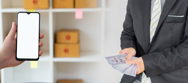 在工作中使用笔记本电脑和电话、手机和纸箱的小企业主，在家使用纸箱的中小企业企业家，在线销售，电子商务。图片下载