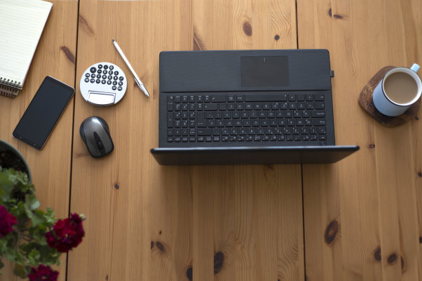 混合办公用品和小工具的木制书桌背景。从以上观点。图片下载