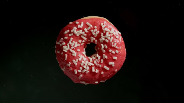 单瓣粉红色甜甜圈在黑色背景上图片下载