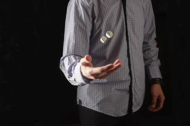 穿衬衫的人掷骰子。骰子漂浮在空中。隔离。图片下载