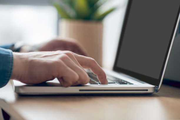 男子的手在笔记本电脑上打字的特写图片图片下载