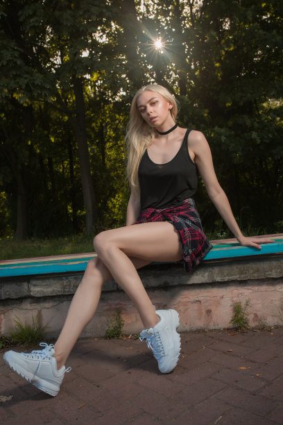 漂亮的金发美女穿着时尚的衣服在公园的长椅上摆姿势图片下载