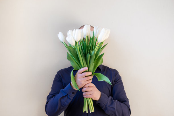 拿着一束郁金香的男人。图片下载