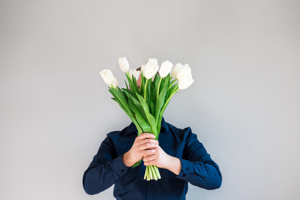 拿着一束郁金香的男人。图片下载