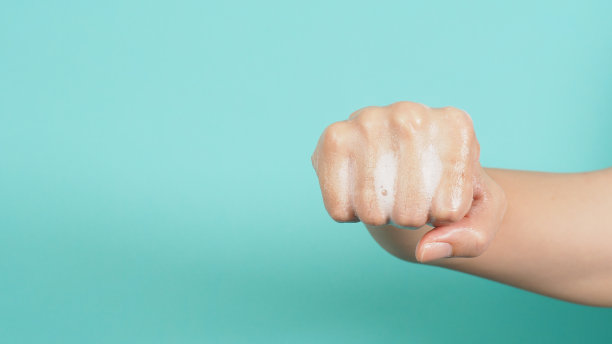 在绿色或蒂芙尼蓝色的背景上，用泡沫洗手皂做打拳或拳击动作。图片下载