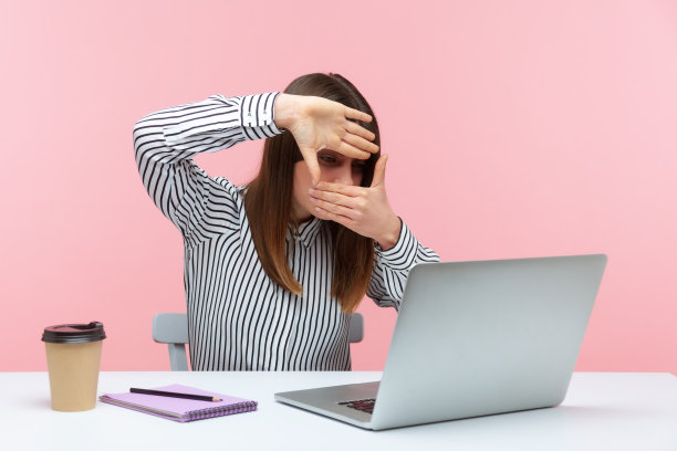 专注的女性设计师或摄影师双手制作相框，聚焦于笔记本电脑屏幕，裁剪图片，捕捉商业创意图片下载