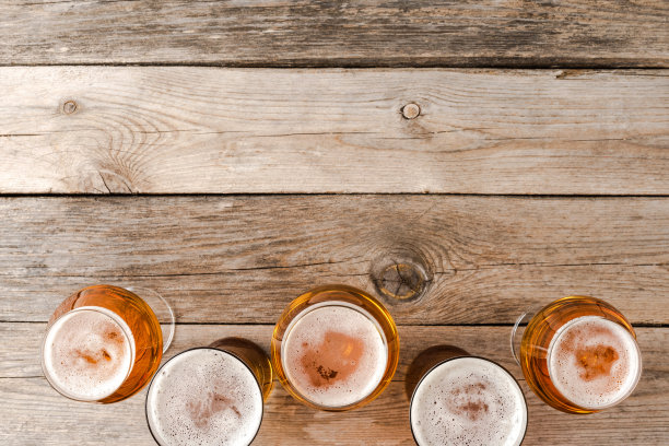 木桌上啤酒杯的头顶镜头。图片下载
