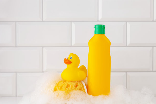 白色背景的婴儿洗发水，橡皮黄色的鸭子，肥皂泡沫。浴室配件图片下载