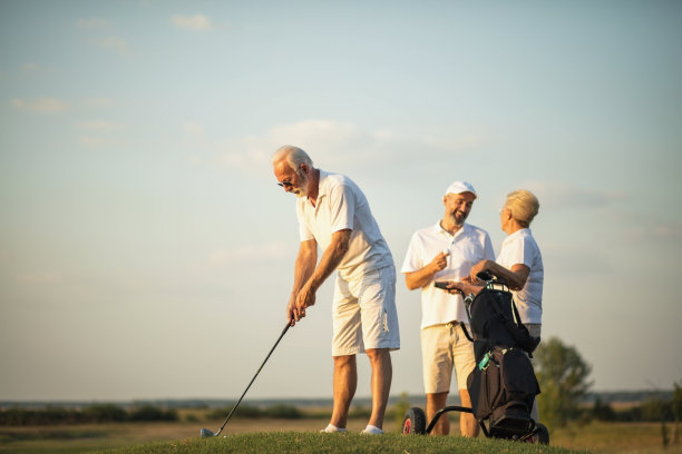 三名资深高尔夫球手在高尔夫球场上。有人在打高尔夫球。图片下载