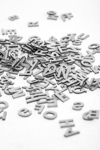 用激光切割机从薄胶合板上剪下的小木字，随机地堆在白色的背景上。黑与白的照片。图片下载
