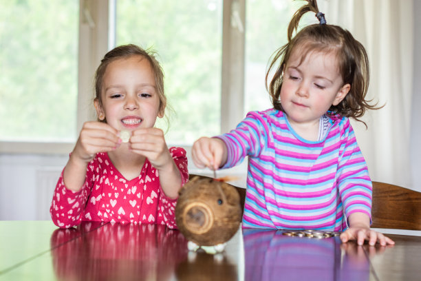孩子们在存钱罐里存钱图片下载