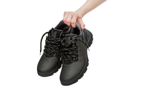 手握一双皮革运动鞋。孤立在白色的。图片下载