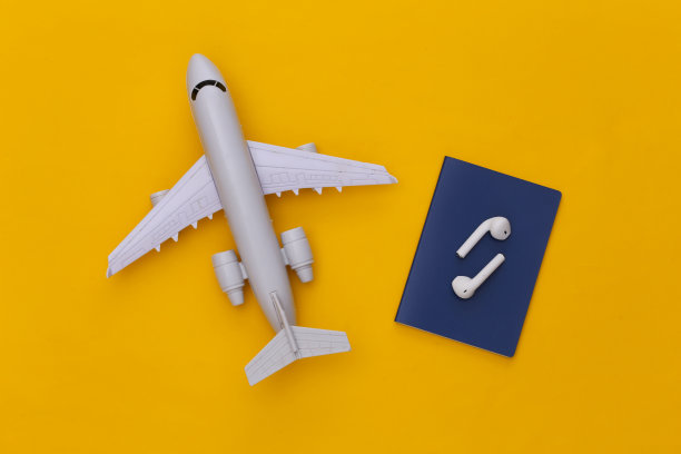 护照和无线耳机，黄色背景上的飞机，旅行概念。俯视图图片下载