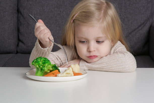 可爱的小女孩在吃蔬菜。节食的概念。孩子的健康饮食习惯。图片下载