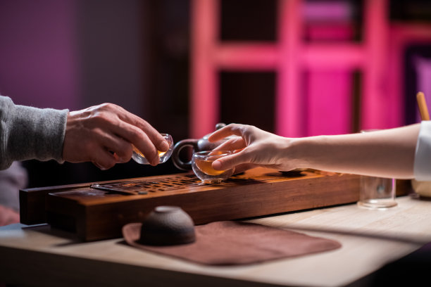 带有模糊背景的大气镜头。男人和女人的手在一个亲密的设置喝香茶在约会。中国茶道的神秘图片下载