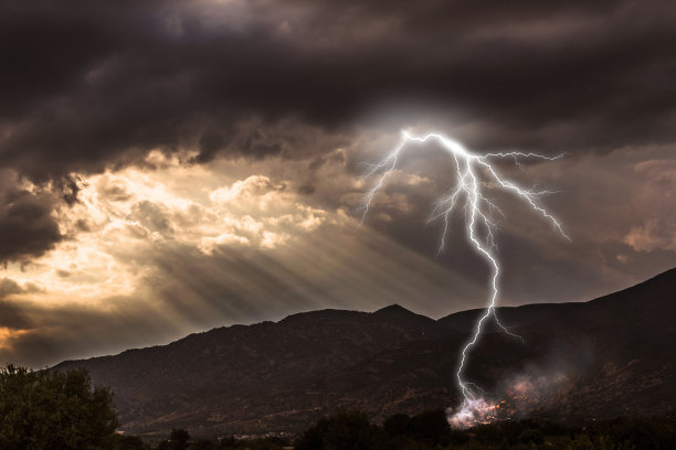 日落中的闪电和山上的森林大火图片下载