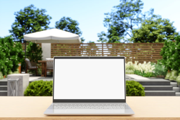 在家工作。笔记本电脑与空白屏幕上的书桌与花园景观背景图片下载