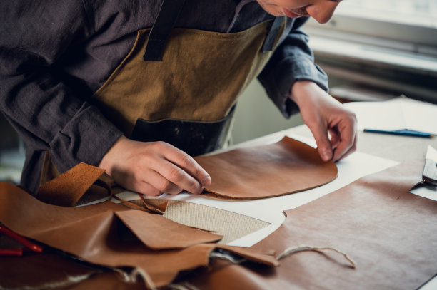一个有才华的年轻人帮助他的父亲打理家族生意，用皮革剪出制鞋的空白图片下载