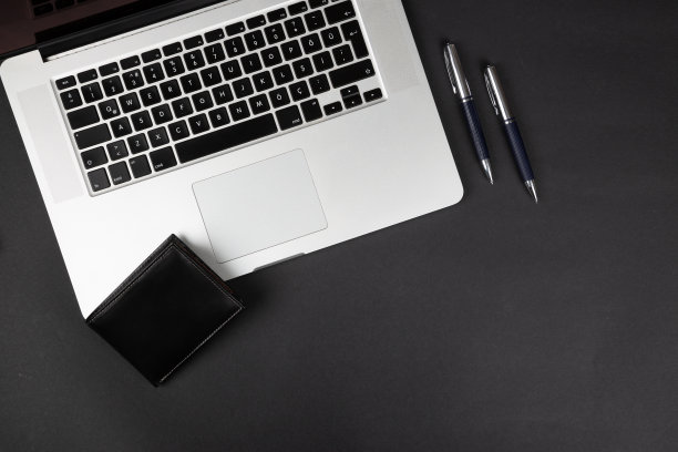 俯视图的笔记本电脑，钱包，钢笔和铅笔在黑色的背景。图片下载