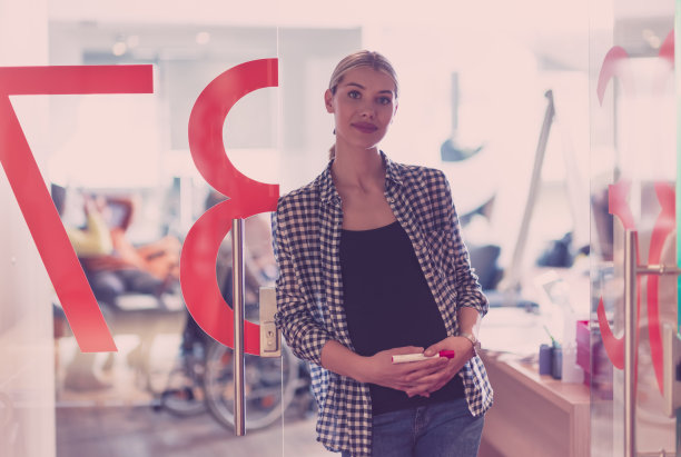 肖像怀孕的女商人温柔地抱着肚子在现代办公室图片下载