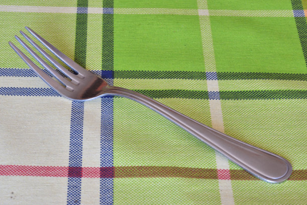 金属叉放在彩色桌布上图片下载