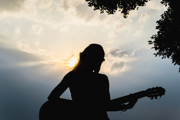 坐着的女人在弹吉他图片下载