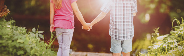 女孩和男孩一起站在公园里。图片下载