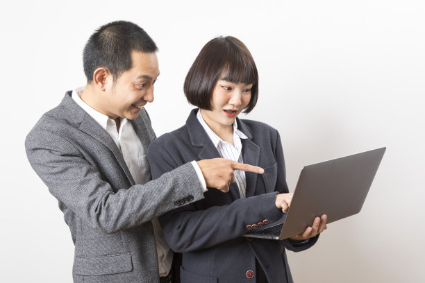 女商人和商人拿着电脑站在白色的背景上。图片下载