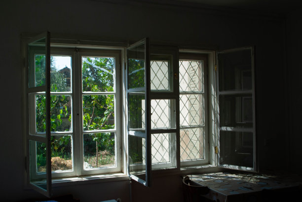 这是一个村庄里的房间，有着古老的窗户和木框。卧室在一个夏天的小屋里，从窗户可以看到绿色的花园。看着房间里的窗户图片下载