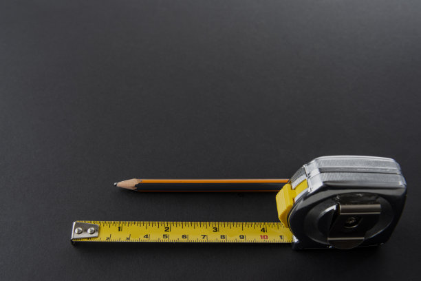 用银色和黄色的铅笔绘制厘米、毫米和英寸的计量单位，并以黑色为背景图片下载