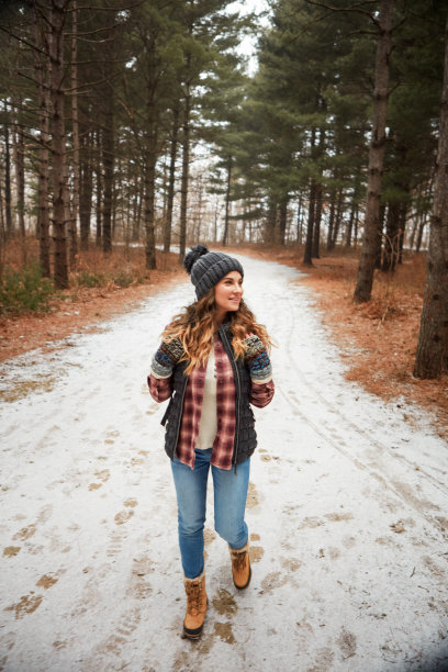 这是一个年轻女子在冬天的荒野中徒步旅行的照片图片下载