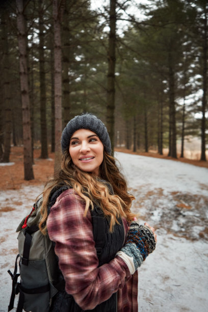 这是一个年轻女子在冬天的荒野中徒步旅行的照片图片下载