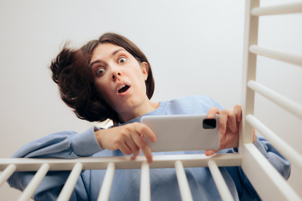 妈妈在用智能手机拍婴儿床里的照片图片下载