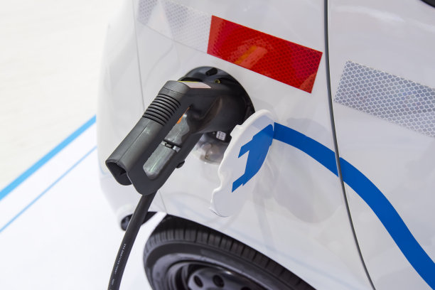 电动汽车在停车场充电用电动汽车充电站。图片下载