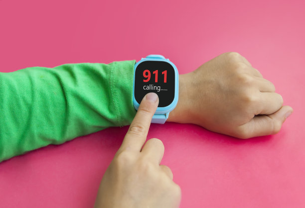小男孩在智能手表上遇到紧急情况时用食指轻敲屏幕。可穿戴儿童智能手表的电话和位置跟踪触摸屏和语音服务图片下载