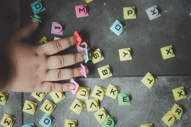 裁剪的手在地板上玩字母的孩子。俯视图图片下载