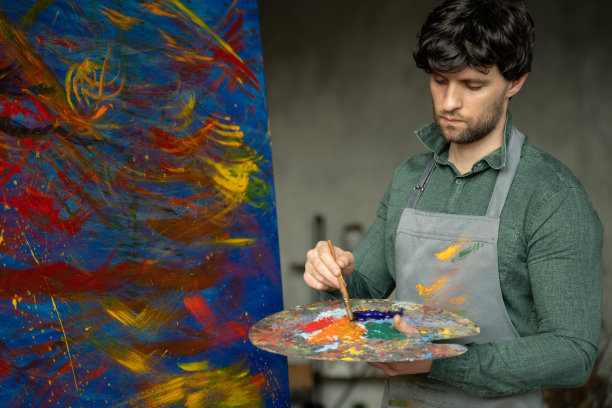 人是艺术家，拿着毛笔，画着一幅抽象画图片下载