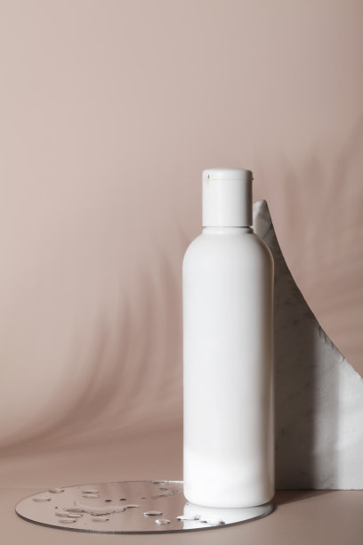 白色瓶子的洗液瓶与石头，镜子与水和热带叶阴影在米色背景。天然有机化妆品概念。图片下载