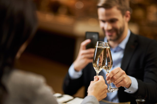 一个优雅的男人在拍两个香槟酒杯图片下载