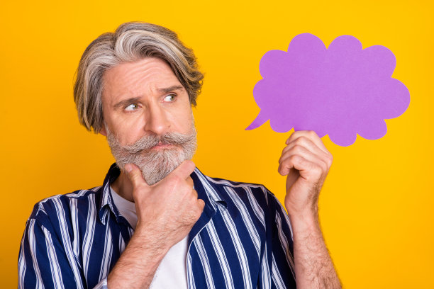 英俊体贴的成熟男人的照片，抱着说话气泡，思考孤立在黄色的背景图片下载