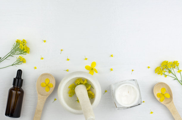 皮肤护理用品制造。由天然草药制成的化妆品套装。药草，灰泥，瓶子和奶油在白色的背景图片下载