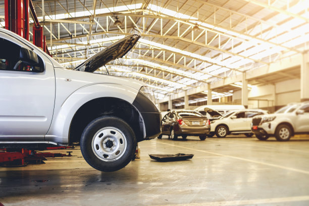 在汽车维修服务中心的汽车，以软焦点和过光为背景图片下载