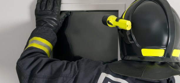 消防队员穿着防护服和安全帽向窗外望去，后视镜，长照片图片下载